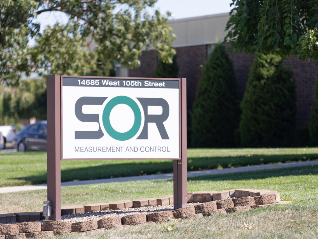 Outdoor sign at SOR corporate headquarters featuring the SOR Measurement and Control logo and address